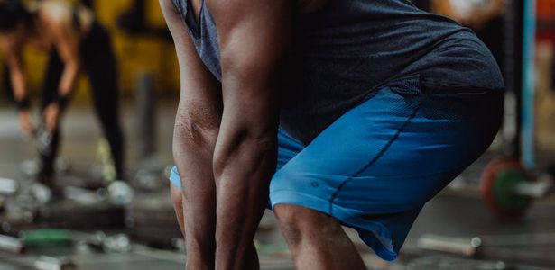 Side view of a man performing a deep squat with controlled movement.